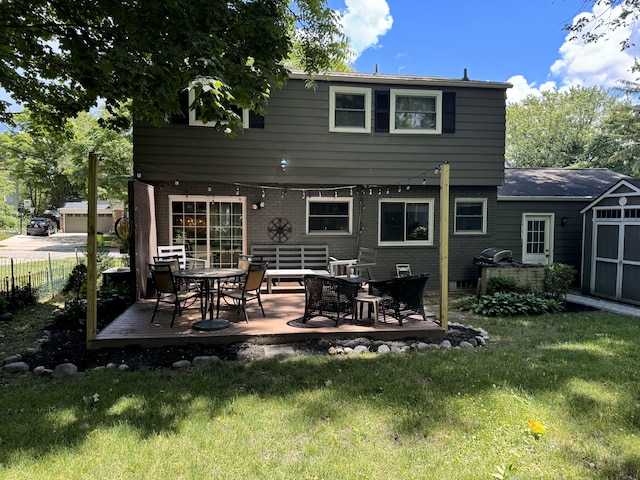 back of property featuring a lawn, an outbuilding, fence, a shed, and brick siding