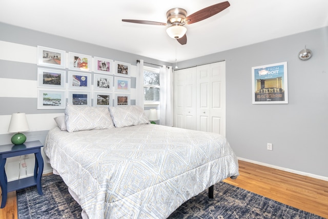 bedroom featuring a ceiling fan, baseboards, a closet, and wood finished floors