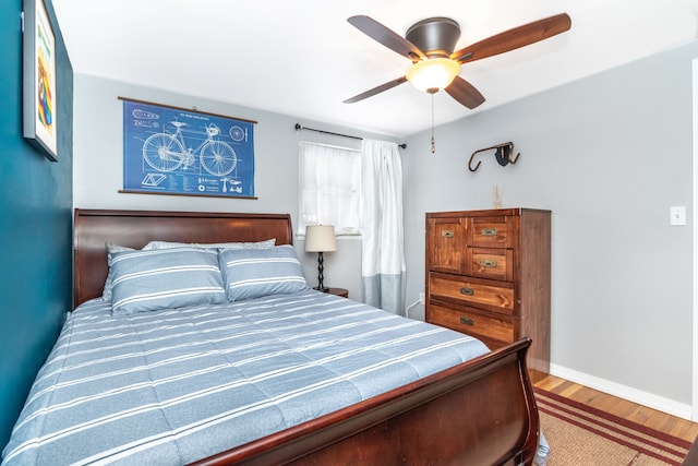 bedroom featuring ceiling fan, wood finished floors, and baseboards