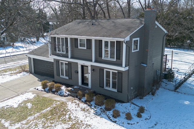 view of front of home featuring brick siding, a chimney, an attached garage, fence, and driveway