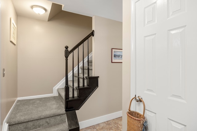 stairway featuring baseboards and tile patterned flooring