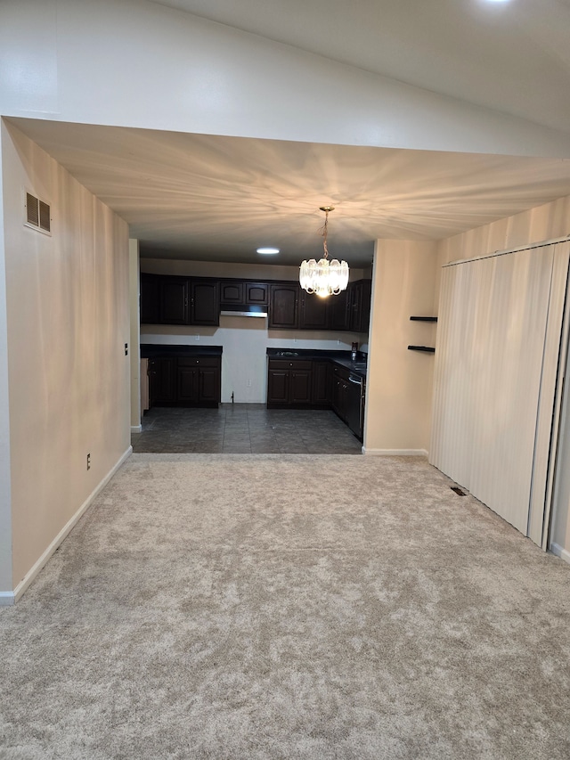 unfurnished living room featuring dark carpet and a chandelier