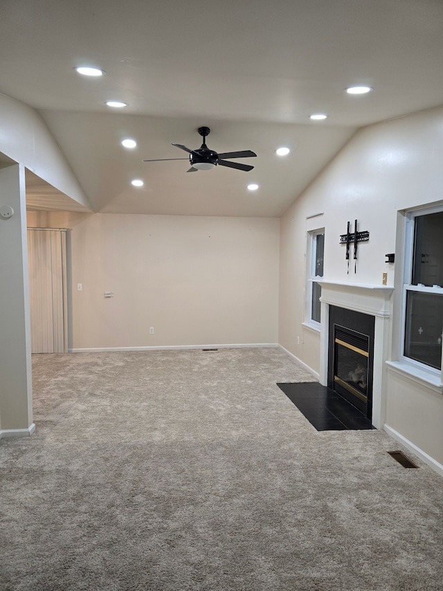 unfurnished living room with ceiling fan, lofted ceiling, and carpet flooring