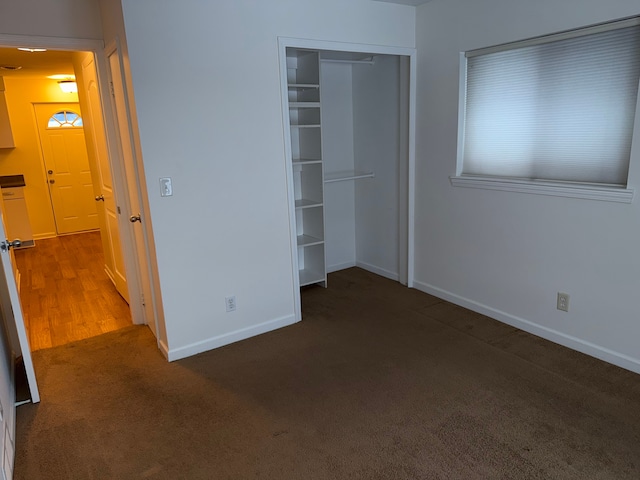 unfurnished bedroom featuring carpet, baseboards, and a closet