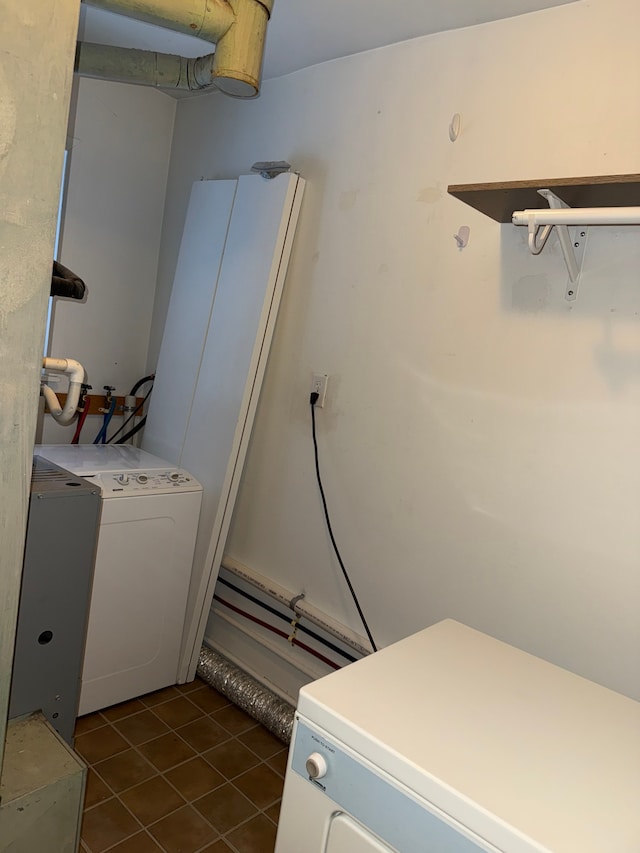 washroom featuring laundry area, washer and dryer, and dark tile patterned flooring