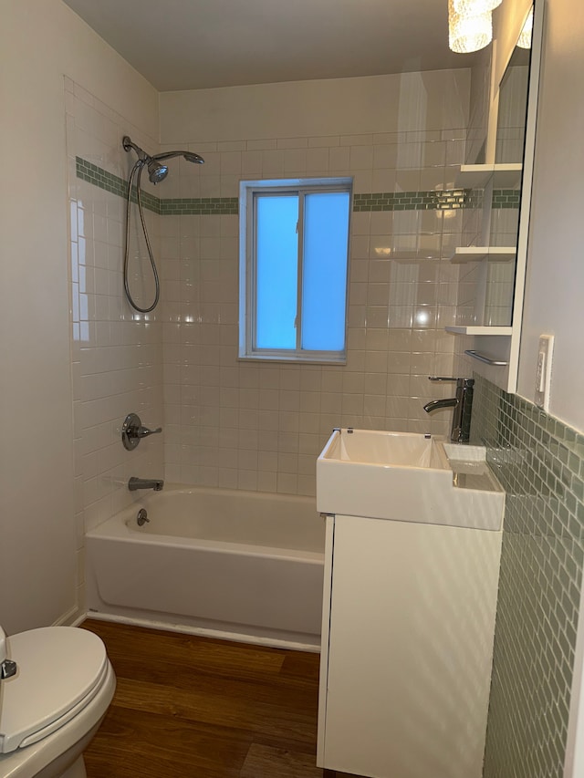 full bath with shower / tub combination, vanity, toilet, and wood finished floors