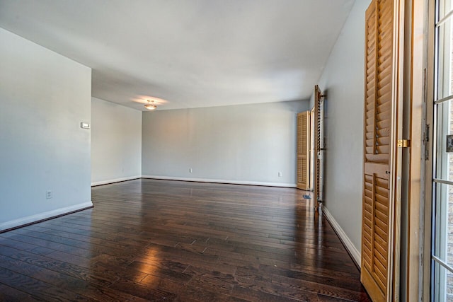 empty room with baseboards and hardwood / wood-style flooring