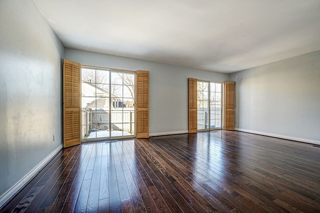 spare room with dark wood-style floors and baseboards