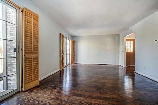 empty room featuring baseboards and hardwood / wood-style flooring