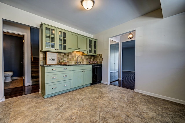 bar with a sink, baseboards, tasteful backsplash, and dishwasher