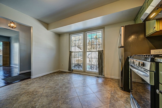 kitchen featuring under cabinet range hood, stainless steel gas range, baseboards, and green cabinetry