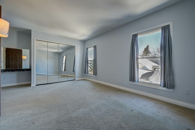 unfurnished bedroom featuring a closet, baseboards, and carpet