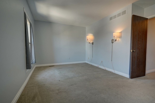 empty room featuring carpet flooring, baseboards, and visible vents