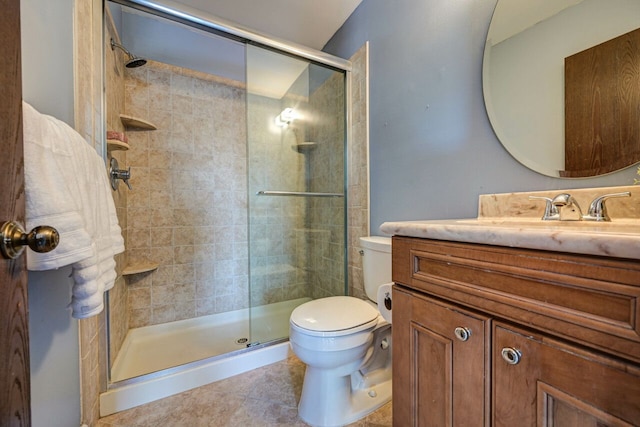 full bath featuring vanity, tile patterned floors, toilet, and a stall shower