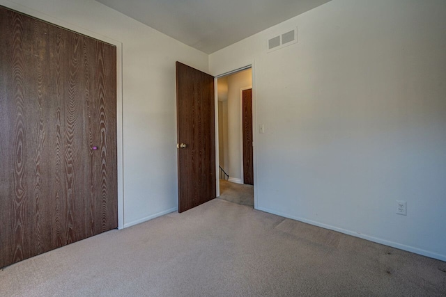 carpeted empty room featuring visible vents and baseboards