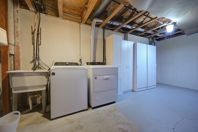 washroom with laundry area, a sink, and separate washer and dryer