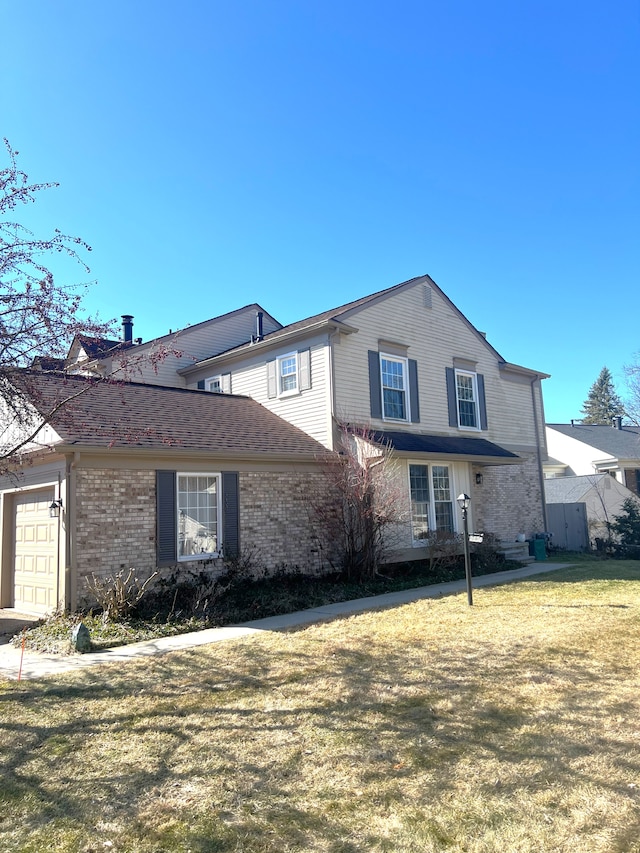 view of front facade featuring a garage, brick siding, and a front lawn