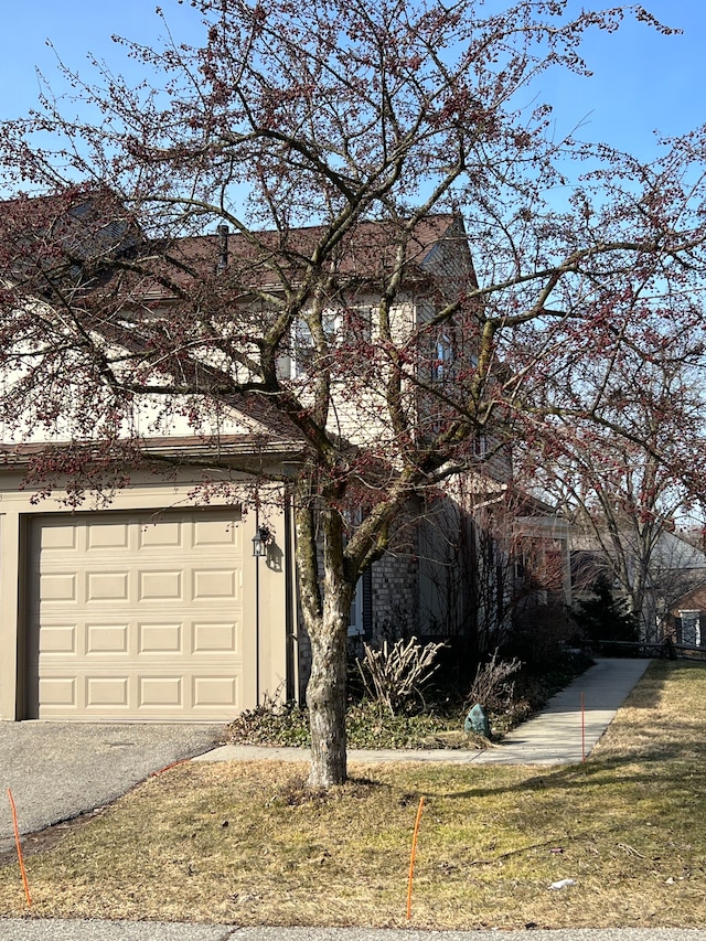 view of front of house featuring driveway, a front lawn, and a garage