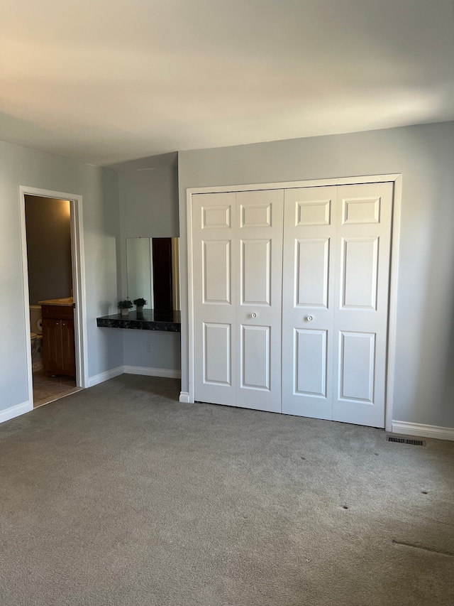 unfurnished bedroom featuring baseboards, a closet, and carpet floors