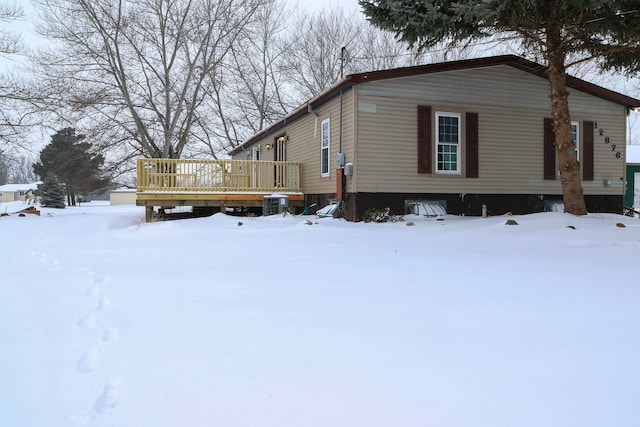 view of snow covered exterior featuring a wooden deck and central AC