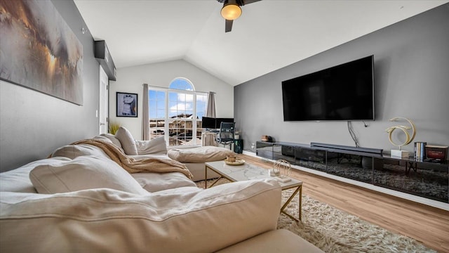 living room with hardwood / wood-style flooring, ceiling fan, and vaulted ceiling