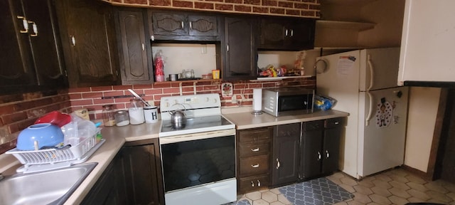 kitchen with dark brown cabinets, sink, white appliances, and decorative backsplash