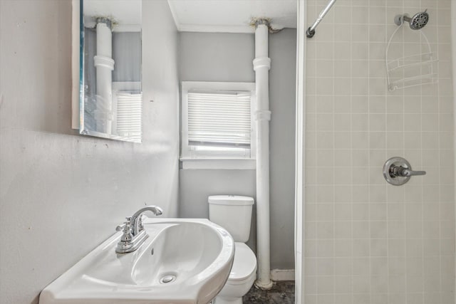 bathroom featuring sink, toilet, and tiled shower