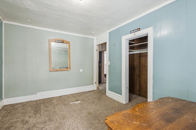 unfurnished bedroom with ornamental molding, carpet floors, and a closet