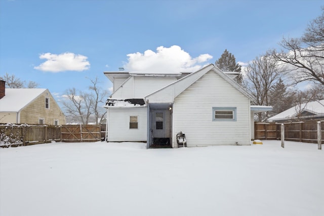 view of snow covered rear of property