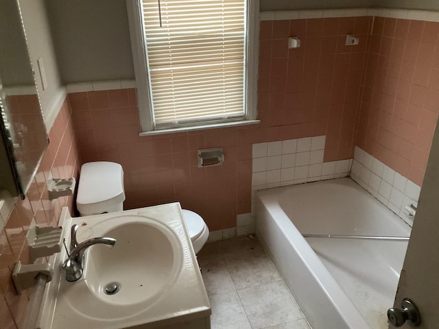 bathroom featuring sink, tile patterned flooring, tile walls, a bath, and toilet