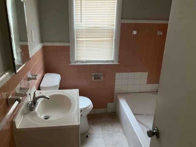 bathroom featuring tile patterned flooring, tile walls, vanity, a bath, and toilet