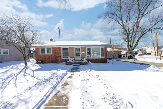 view of front of house with a garage, brick siding, and a chimney