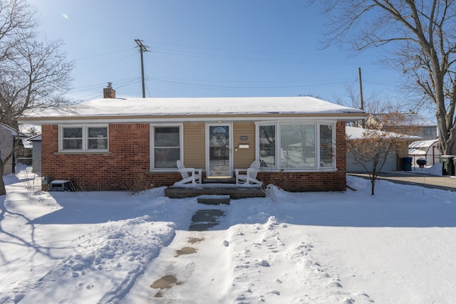 view of front of house with a garage, brick siding, and a chimney