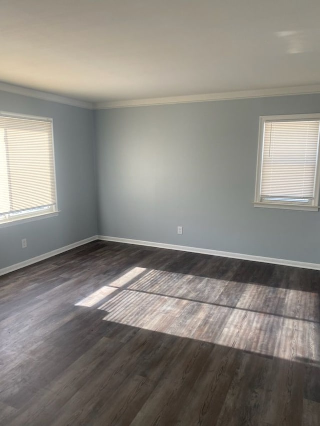 empty room with dark wood-type flooring and ornamental molding