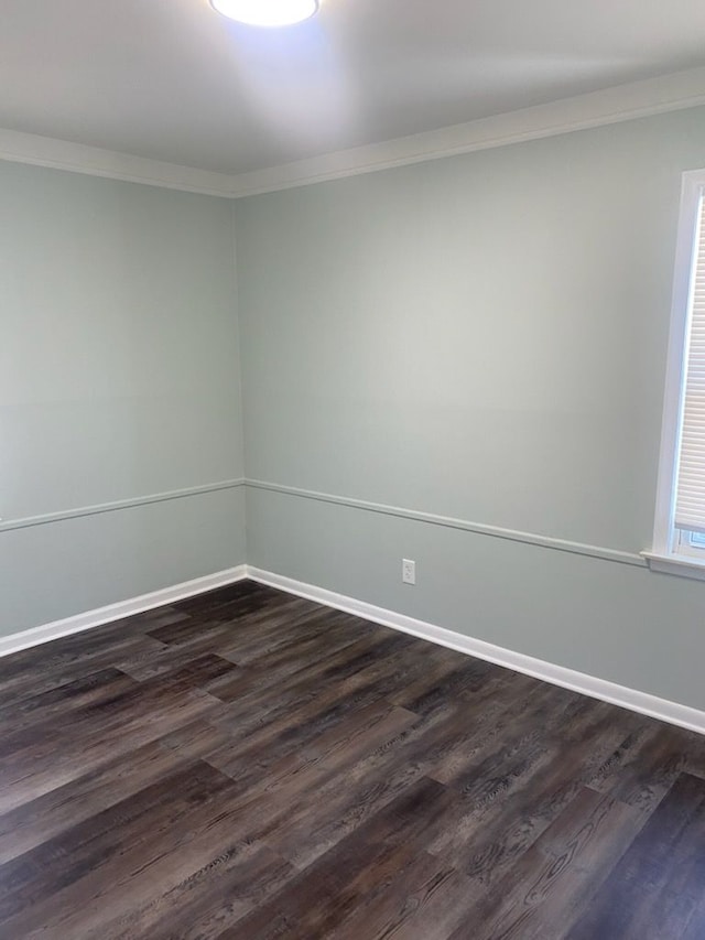 empty room with dark hardwood / wood-style flooring and ornamental molding