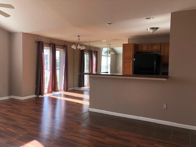 kitchen featuring black fridge, ceiling fan, a healthy amount of sunlight, and decorative light fixtures