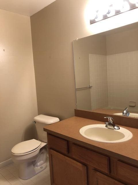 bathroom featuring vanity, tile patterned flooring, and toilet