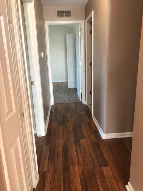 corridor with dark hardwood / wood-style flooring