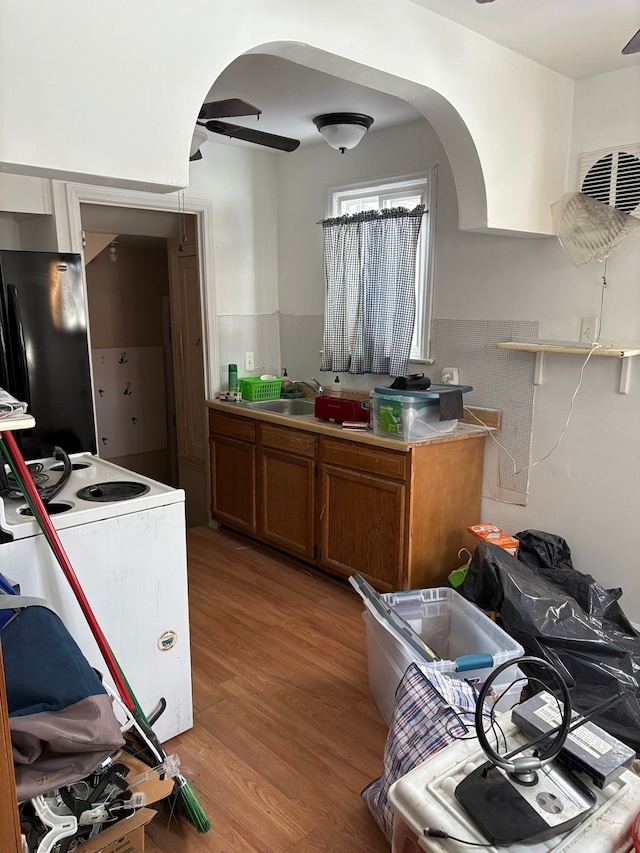 kitchen with black fridge, ceiling fan, light hardwood / wood-style flooring, and electric range