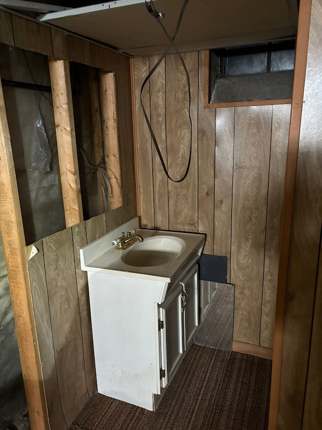 bathroom featuring wood walls and vanity