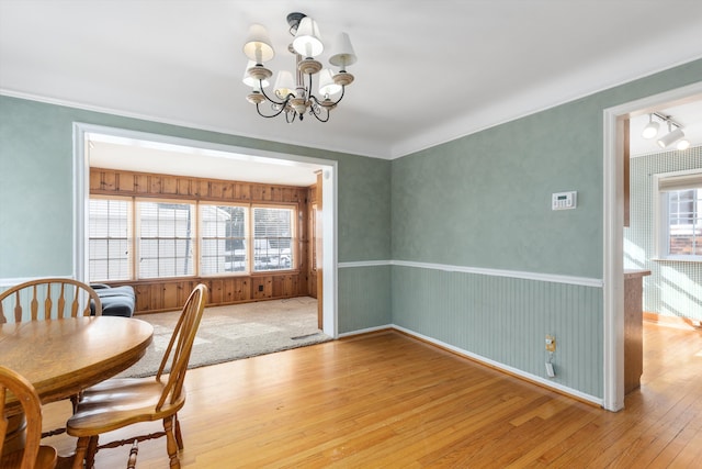 dining area featuring hardwood / wood-style floors, a chandelier, a wealth of natural light, and ornamental molding