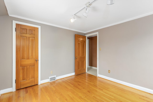 unfurnished bedroom with ornamental molding and light hardwood / wood-style floors