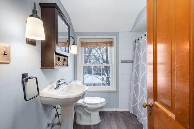 bathroom with hardwood / wood-style flooring, toilet, and walk in shower