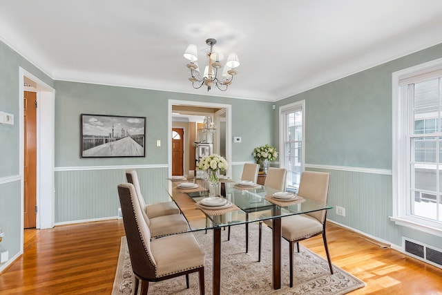 dining space featuring a notable chandelier, a healthy amount of sunlight, and hardwood / wood-style floors