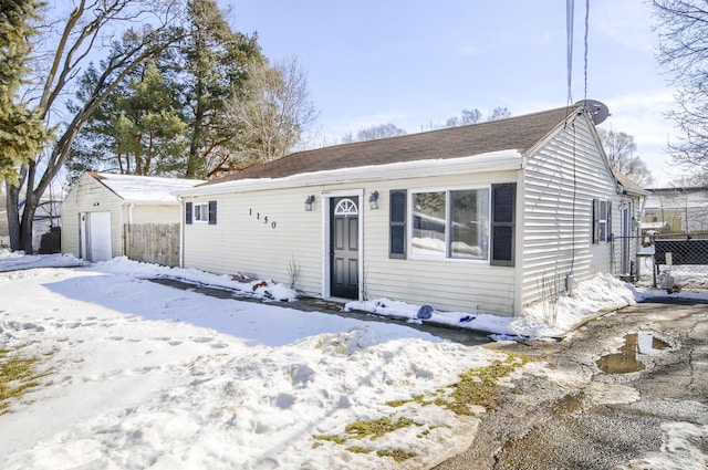 view of front of property featuring a detached garage and fence