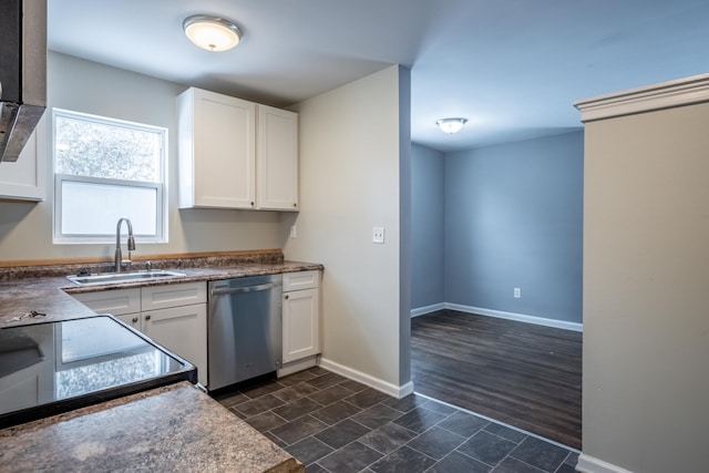 kitchen with a sink, baseboards, white cabinetry, and stainless steel dishwasher