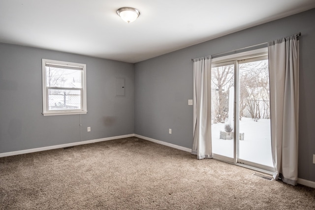 empty room featuring carpet floors, baseboards, and visible vents