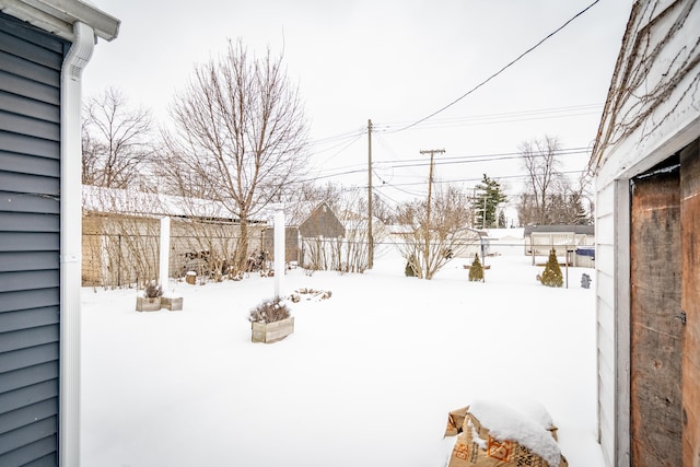 snowy yard featuring fence