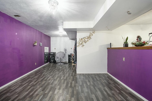 basement with dark wood-type flooring and a textured ceiling