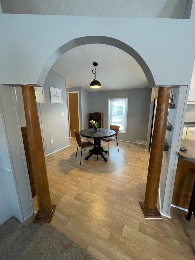 dining space featuring light hardwood / wood-style floors and a textured ceiling